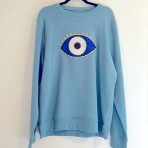 Sweater with evil eye embellishment.